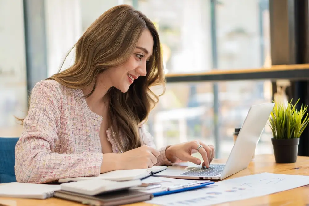 Asian businesswoman, professional millennial woman or female financial analyst working on financial graphs and chart data in the office.