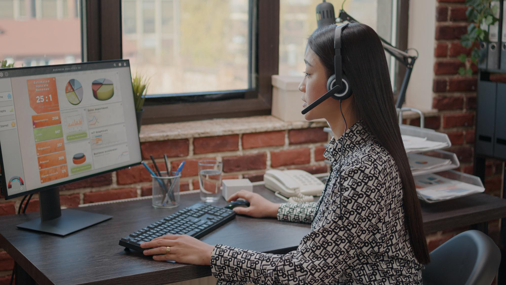 Close up of asian woman with headphones talking on phone call to people at customer service