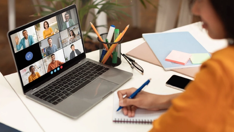 Business woman female team leader manager executive having hybrid office business group meeting, remote workers discussing work plans by video digital conference call on laptop. Over shoulder view