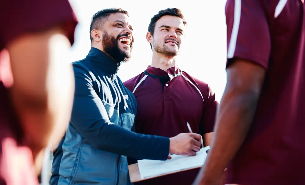 happy coach engaging with team in huddle