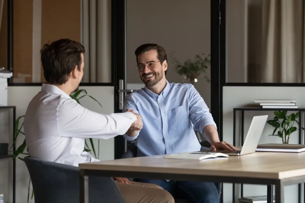 Happy business men giving handshakes after negotiations