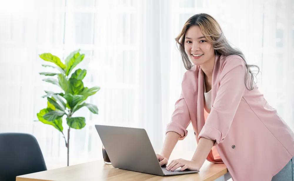 Portrait smile beautiful business asian creative woman pink suit working on her laptop