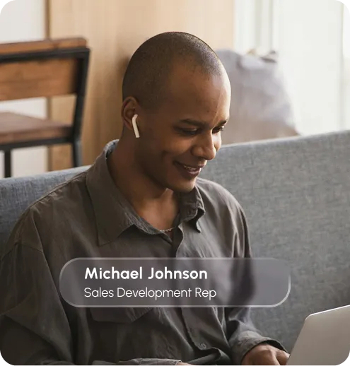 A man on a couch, engaged with his laptop, displaying a casual and relaxed demeanor in a home environment.