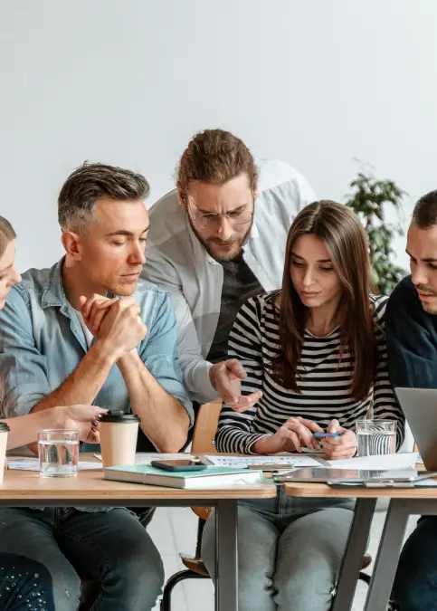 group of coworkers working on project together at desk