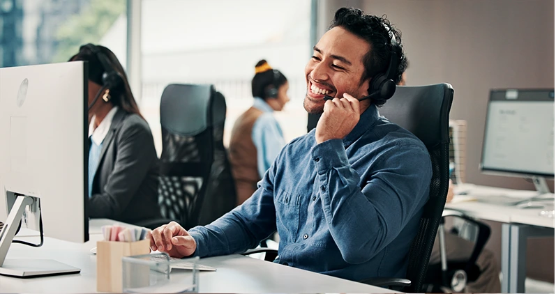Call center, smile or man in office with headset, contact us or communication in customer service. Happiness, coworking or consultant in agency with tech, advisory or telecom in client assistance.